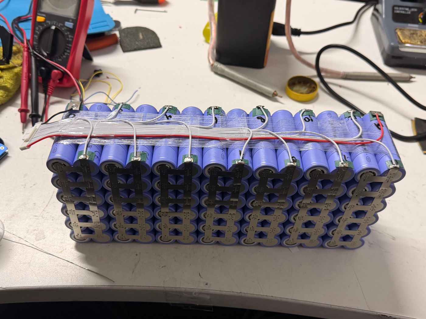 Pack de celdas 18650 con tiras de níquel soldadas por punto y cableado de balanceo, en el taller de Lithium Energy
